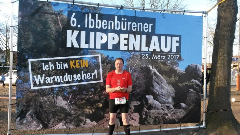Läufer steht vor dem Banner des 6. Ibbenbürener Klippenlaufs am 25. März 2017, das den Slogan „Ich bin KEIN Warmduscher!“ zeigt.