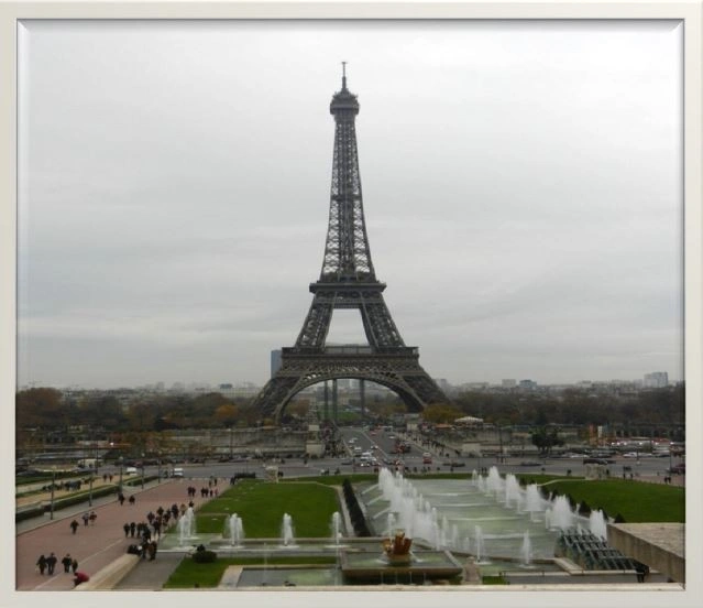 Eiffelturm in Paris mit Blick auf die umgebenden Brunnen und den Platz, an einem bewölkten Tag.