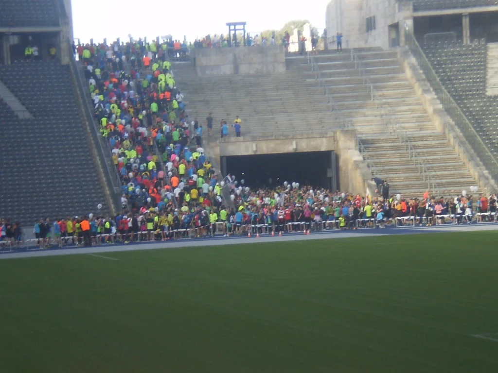 Menschenmenge in bunten Shirts bei einer Sportveranstaltung in einem Stadion, die Treppen hinaufsteigend.