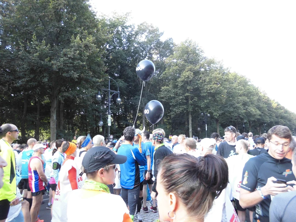 Läufer bei einem Marathon-Event im Park mit Ballons. Großer Ansturm auf den Start des Rennens.