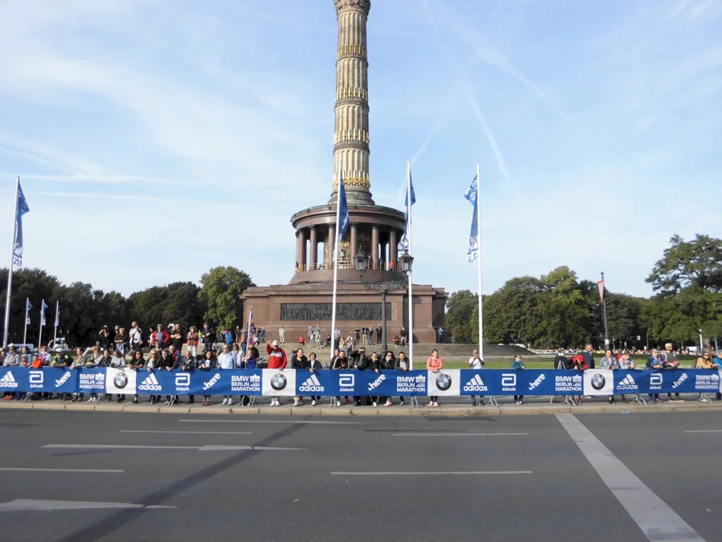 Menschenmengen beim Berlin Marathon 2019 vor der Siegessäule an einem sonnigen Tag.