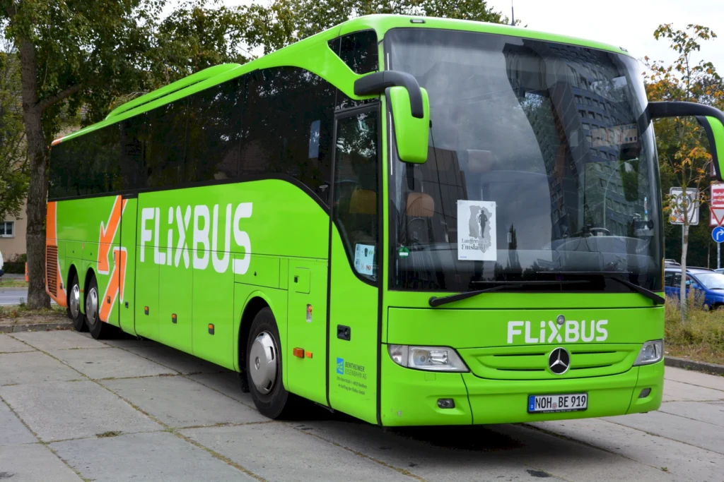 Grüner Flixbus-Personenbus auf einem Parkplatz, bereit für den Fernverkehr.