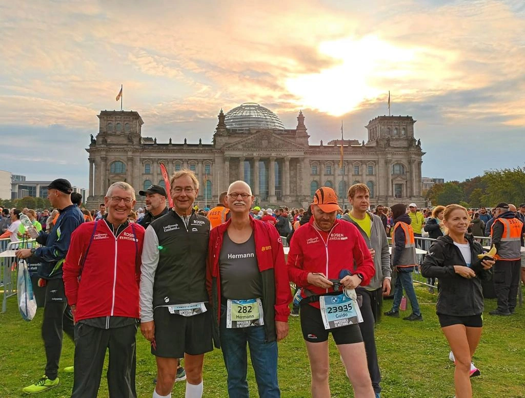 Läufer vor dem Berliner Reichstagsgebäude bei Sonnenuntergang, Teilnehmer beim Marathon-Event in Deutschland.