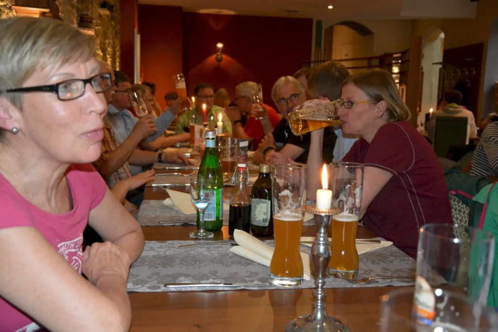 Menschen genießen Bier und Gespräche in einem gemütlichen Restaurant mit Kerzenlicht.