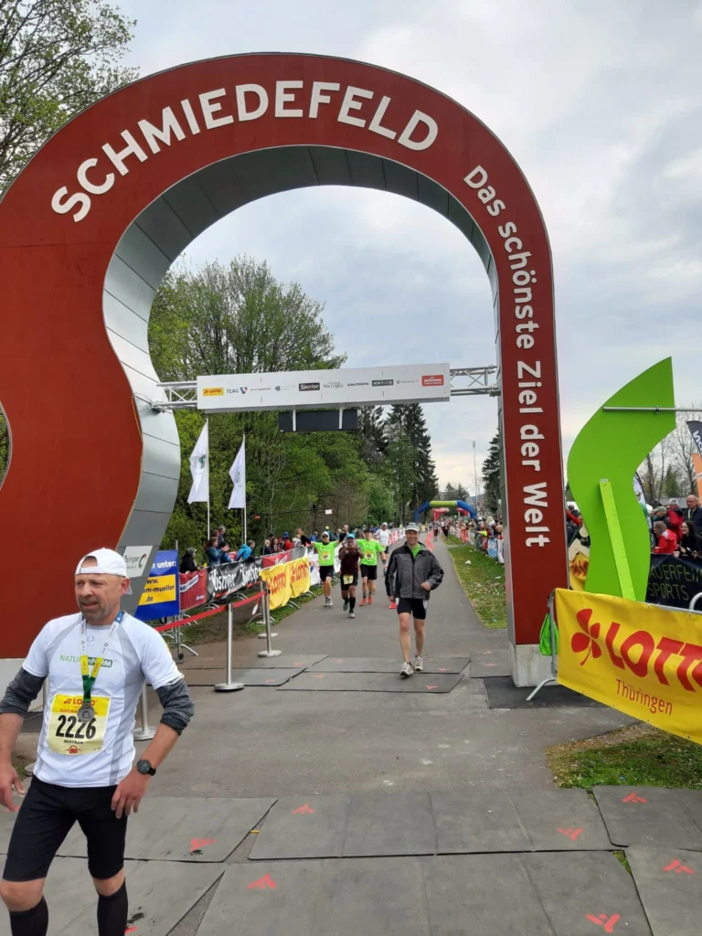 Läufer überqueren das Ziel am Schmiedefeldbogen beim Rennsport-Event.